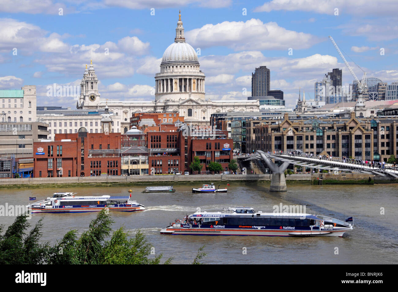 River Thames fast passenger Clipper boats passing St Pauls Cathedral and Millennium footbridge Stock Photo