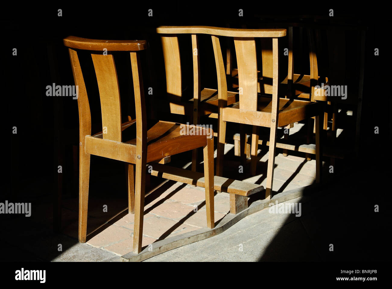 Sunlit church chairs, Pommiers-en-Forez, Loire département, France Stock Photo
