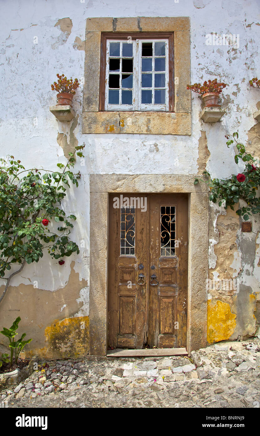 Rustic Brown Wood Door with Peeling Paint in the Medieval Village of Obidos Stock Photo