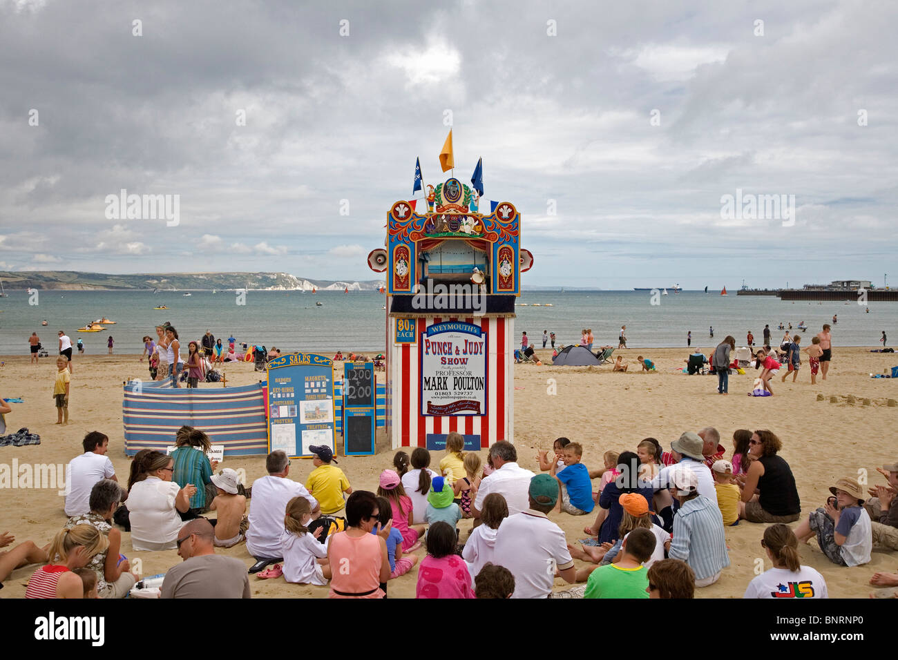 Traditional Punch & Judy show on Weymouth beach with beach and sea in the background Stock Photo
