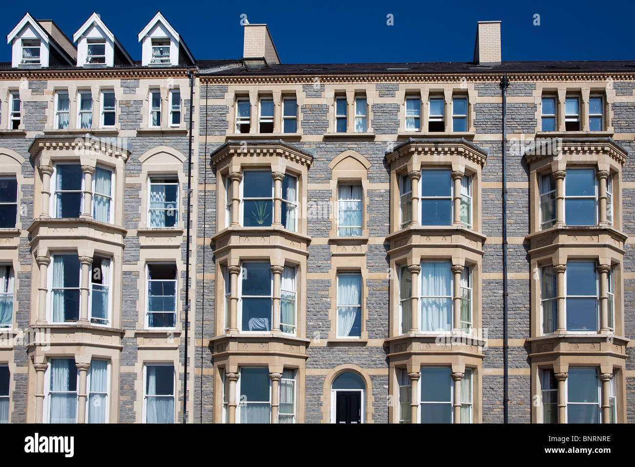 Part of the restored in 2000 Pumlumon and Caerleon buildings on sea front with original on left Aberystwyth Wales UK Stock Photo