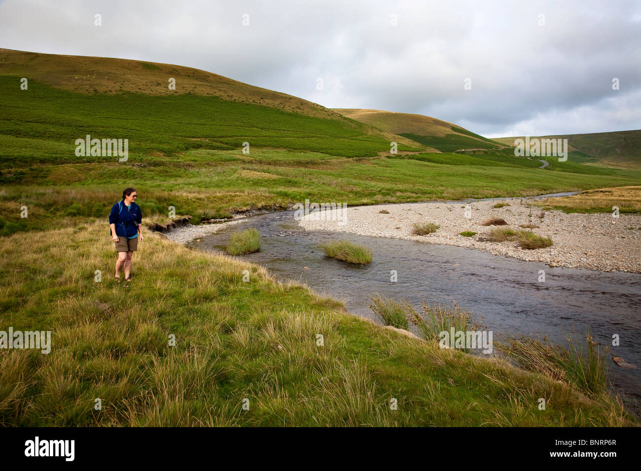 Female hiker at the Elan River on the Monks Trod ancient footpath Wales UK Stock Photo