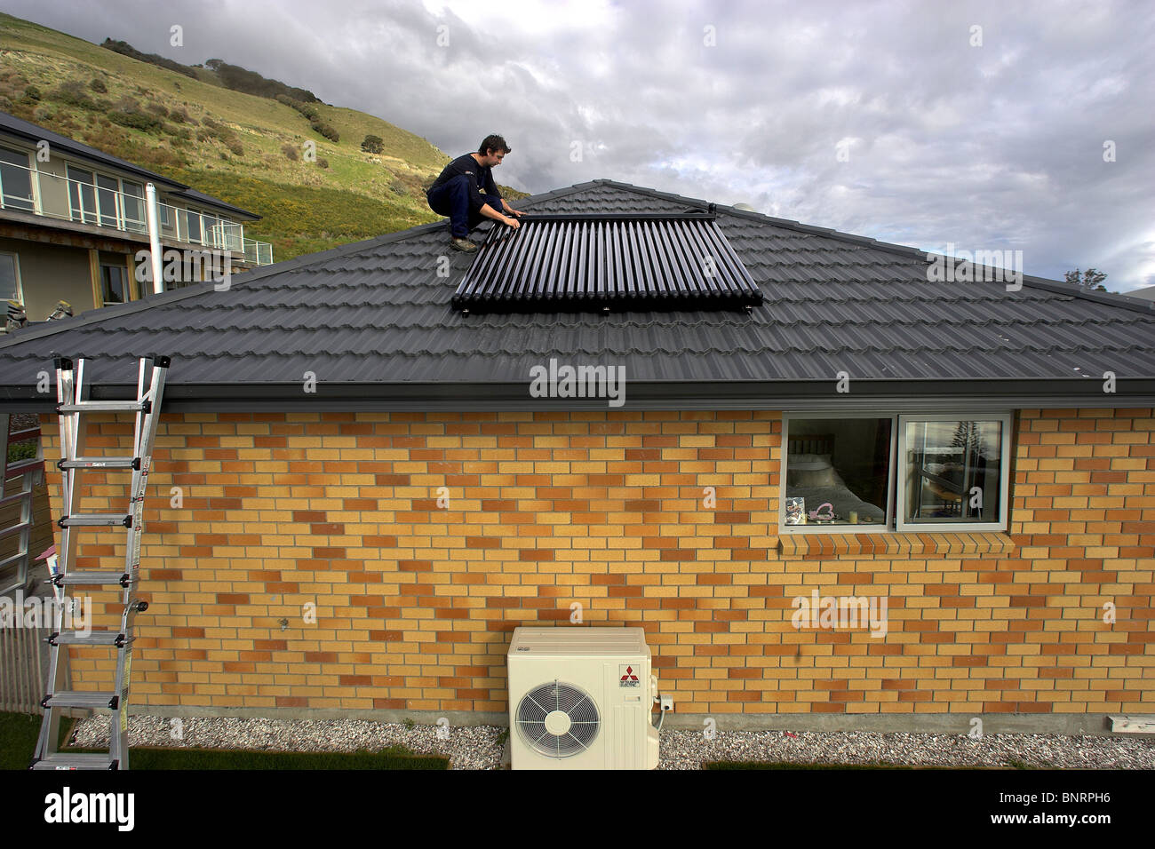 Qualified tradesman installing solar hot water system to a house