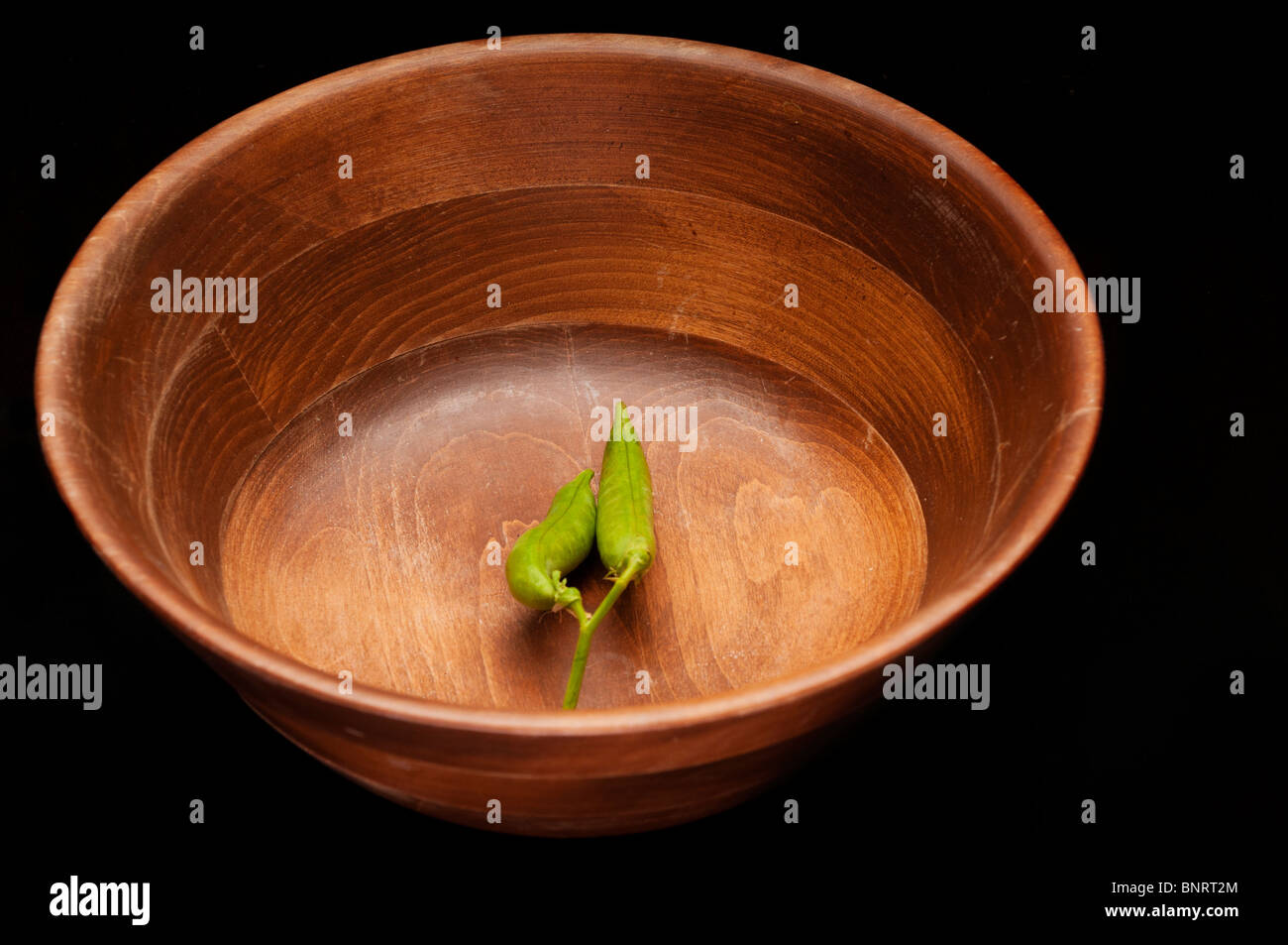 Two pods of peas in a bowl, still life Stock Photo