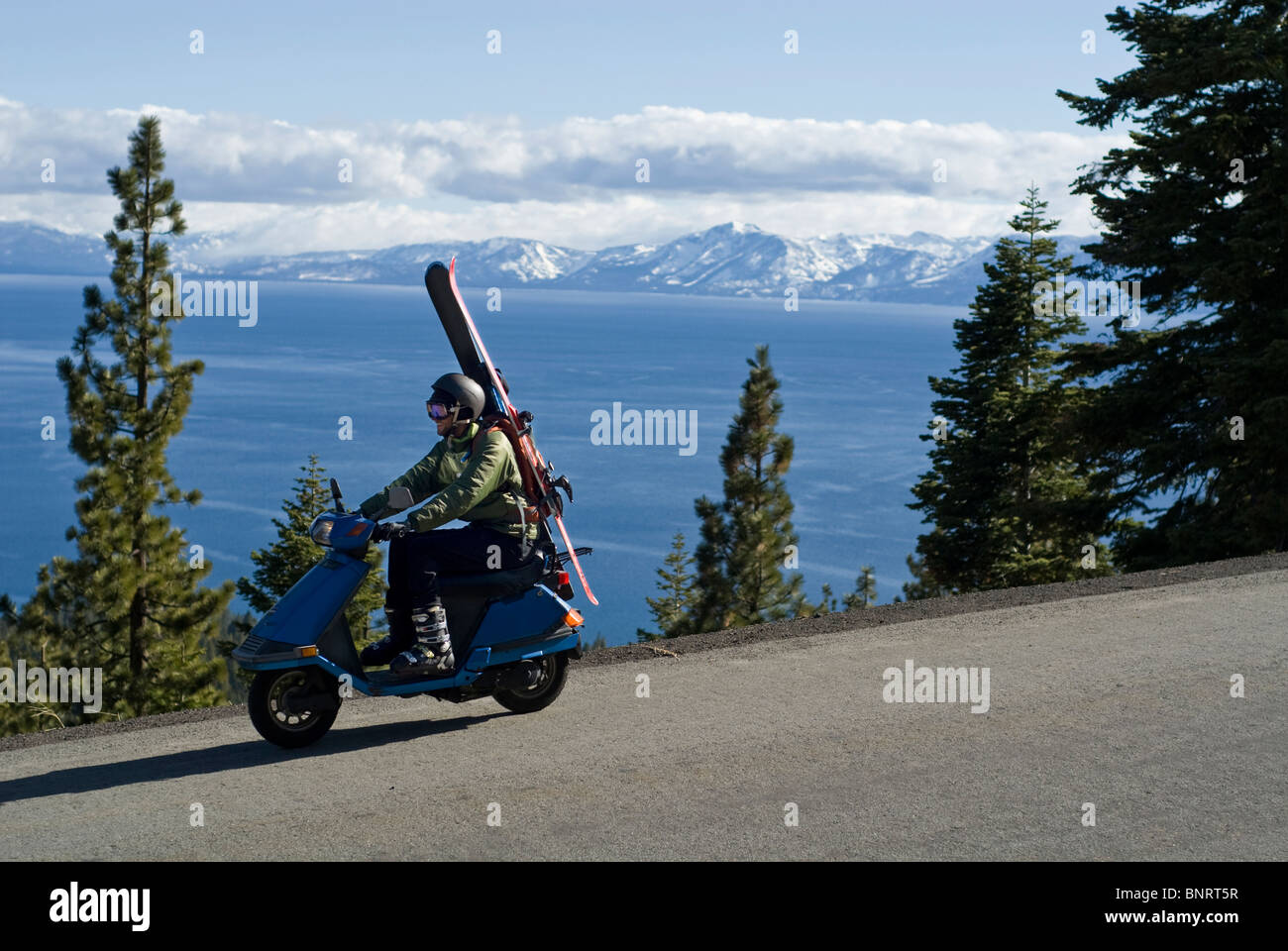Heading out for an afternoon ski run, a young man rides a scooter to