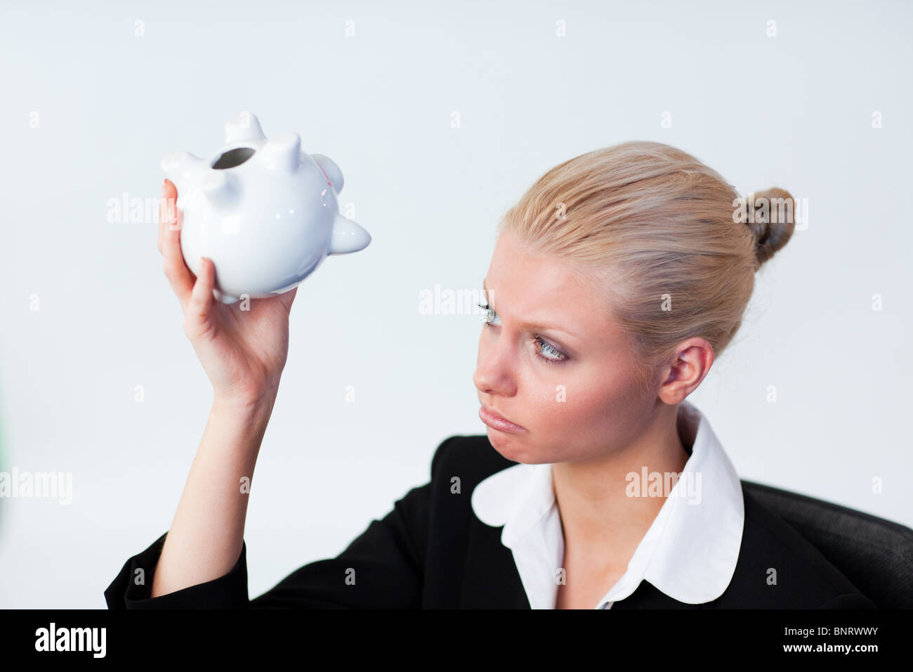Sad Business woman looking into Piggy Bank Stock Photo - Alamy