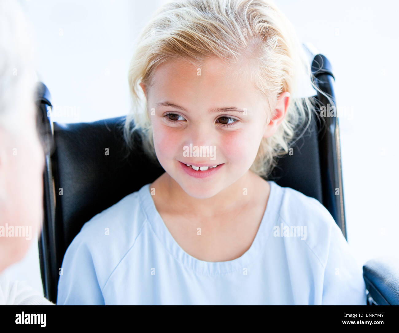 Blond little girl sitting on a wheelchair Stock Photo