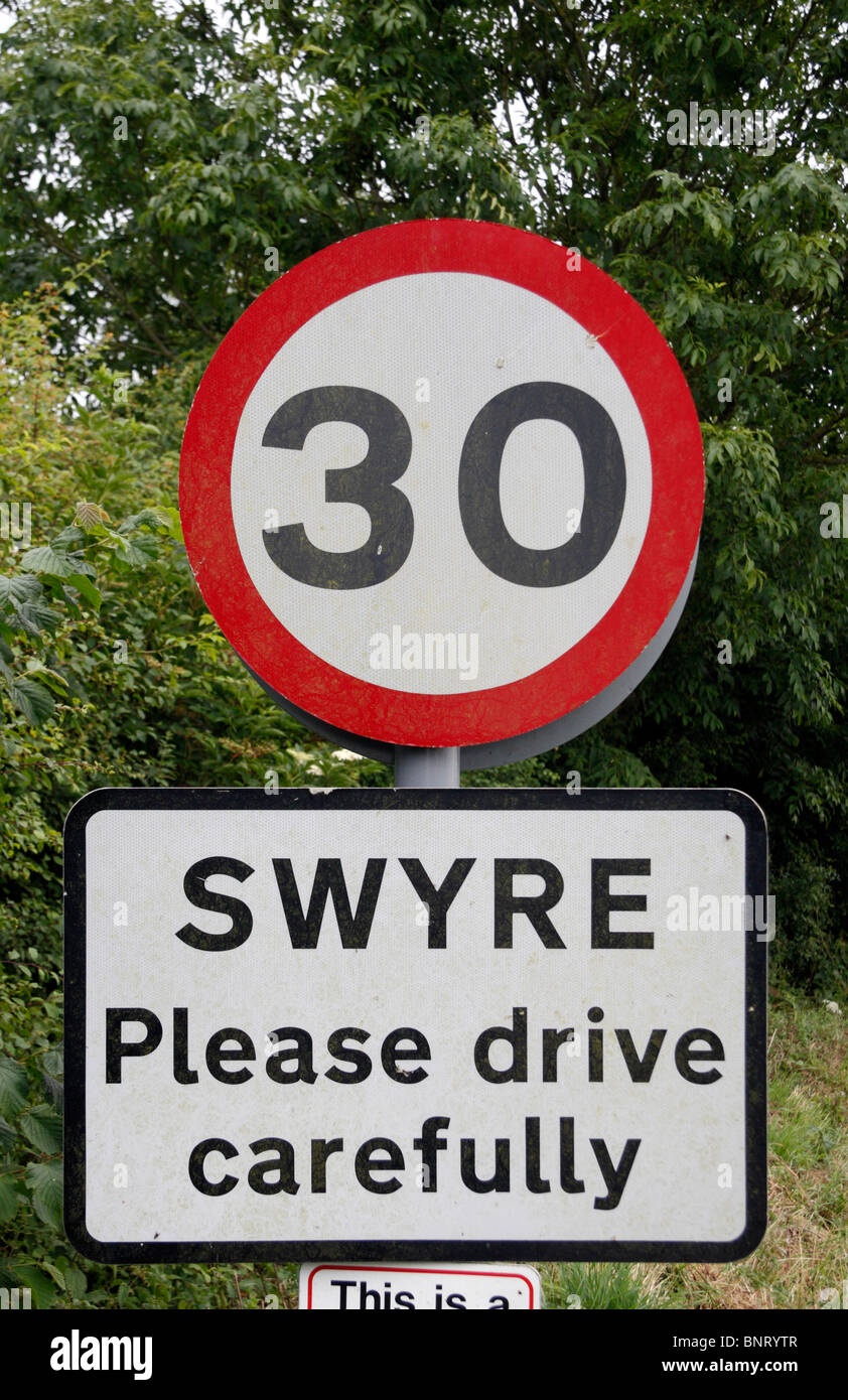 30mph speed limit sign & 'Please drive carefully' sign at the entrance to the small Dorset village of Swyre, UK. Stock Photo