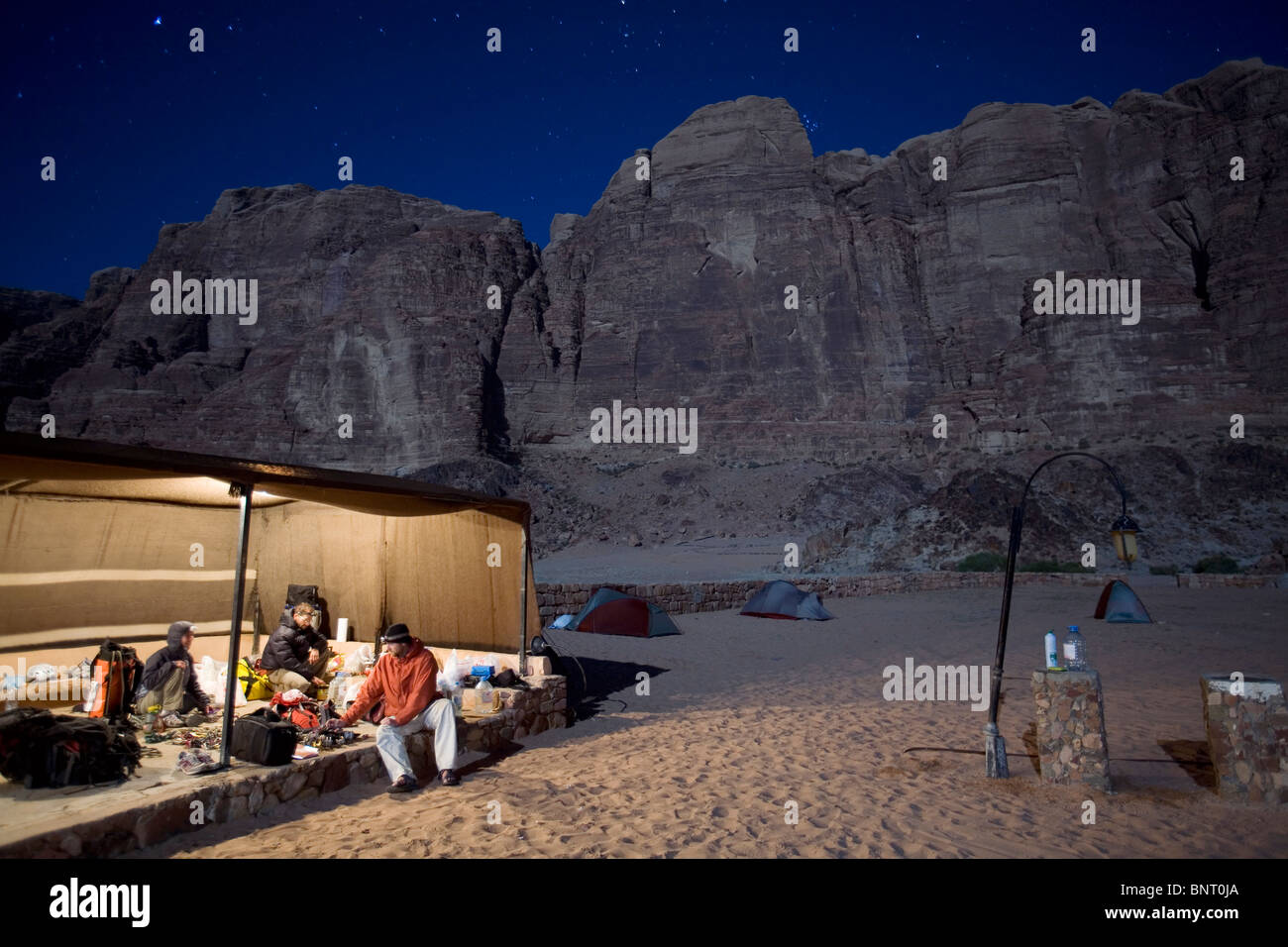 Three climbers organize gear in tent under starry sky Stock Photo - Alamy
