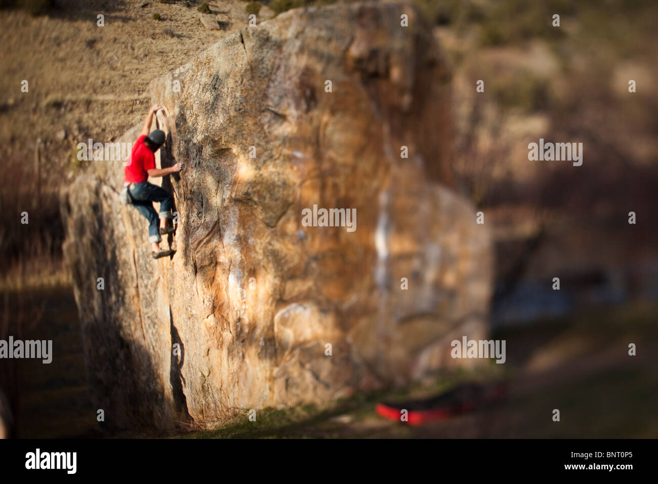 A rock climber works on bouldering problem in Colorado. Stock Photo