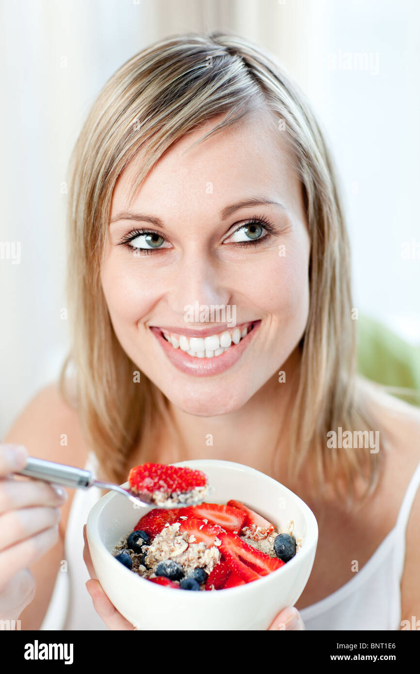 Delighted woman eating muesli with fruits Stock Photo Alamy
