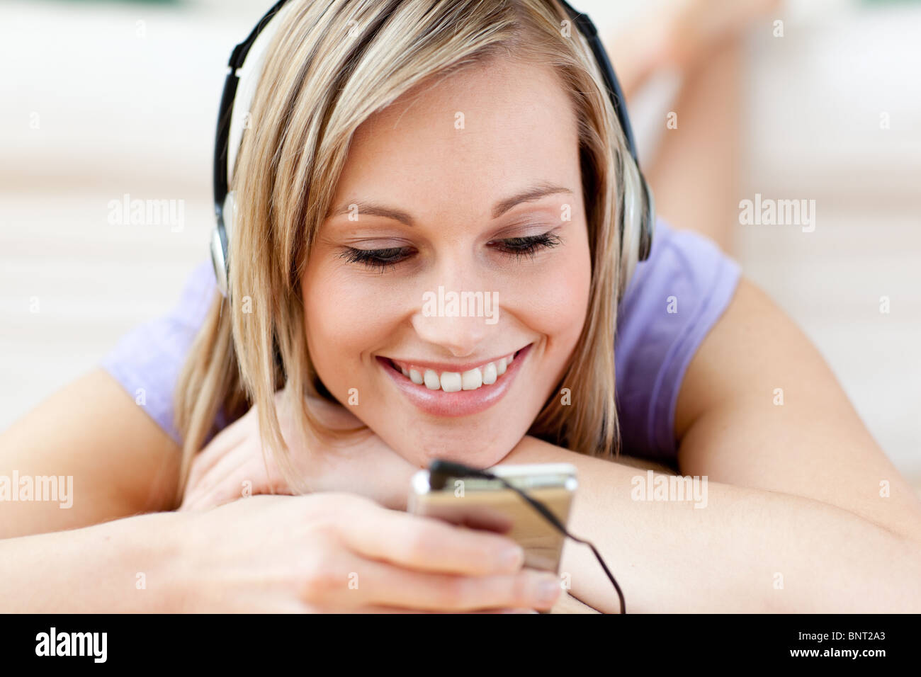 Cheerful woman listening music lying on the floor Stock Photo - Alamy