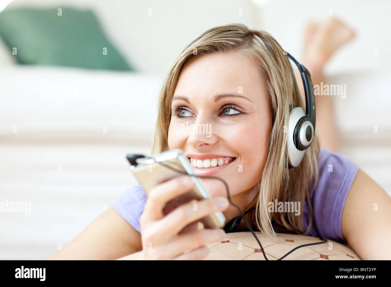 Cheerful woman listening music lying on the floor Stock Photo - Alamy