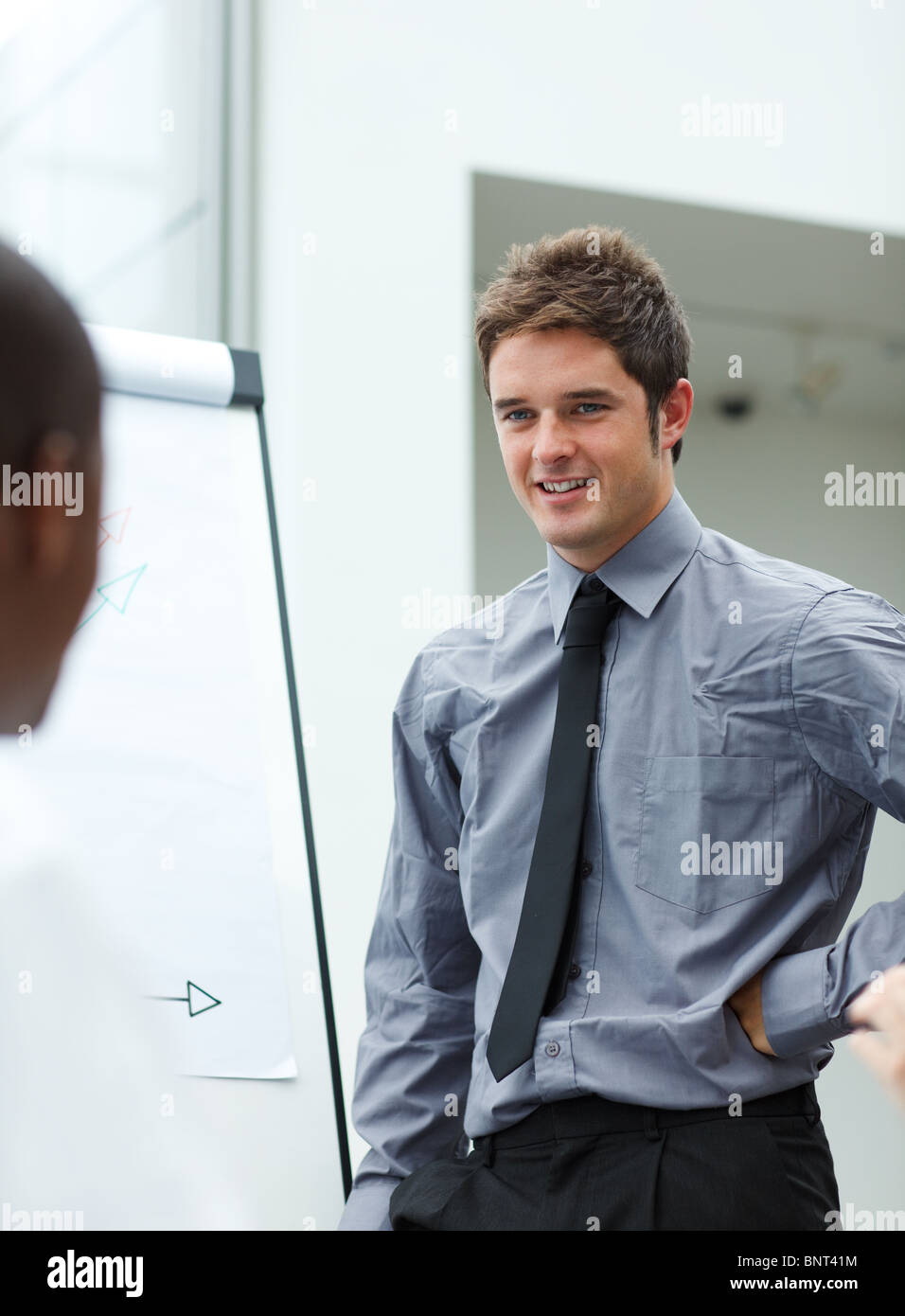 Smiling young businessman giving a presentation Stock Photo - Alamy