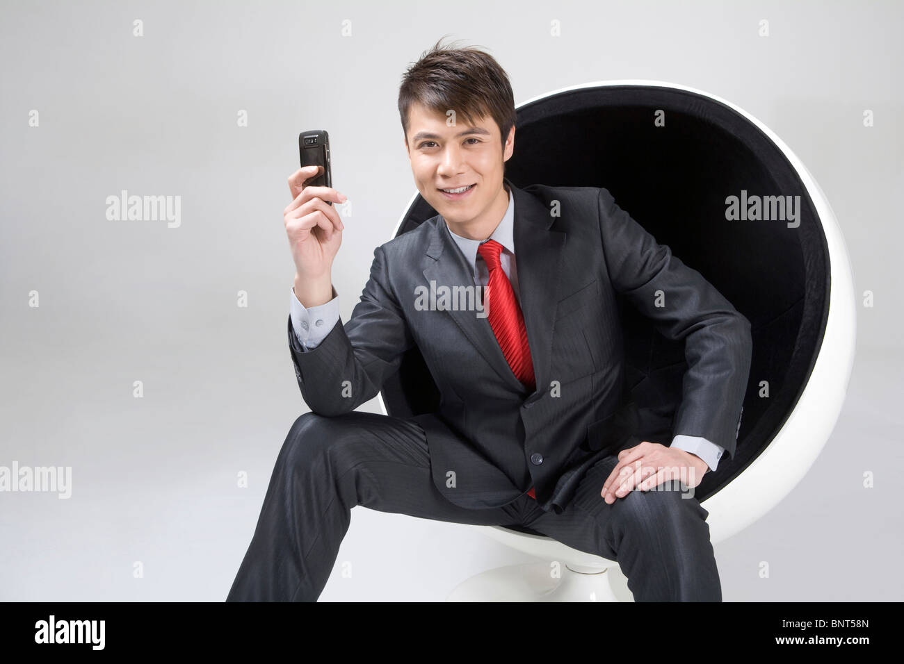 Confident young businessman sitting in a ball chair Stock Photo - Alamy