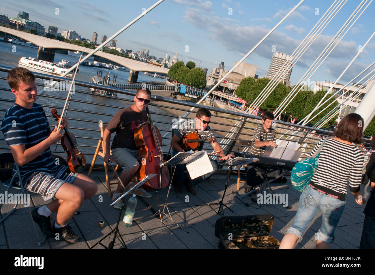 A string quartet busks on Hungerford bridge near Waterloo Stock Photo