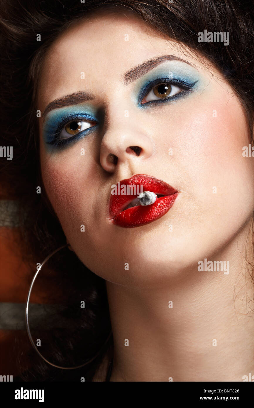 close up portrait of girl maked up like hooker smoking Stock Photo -