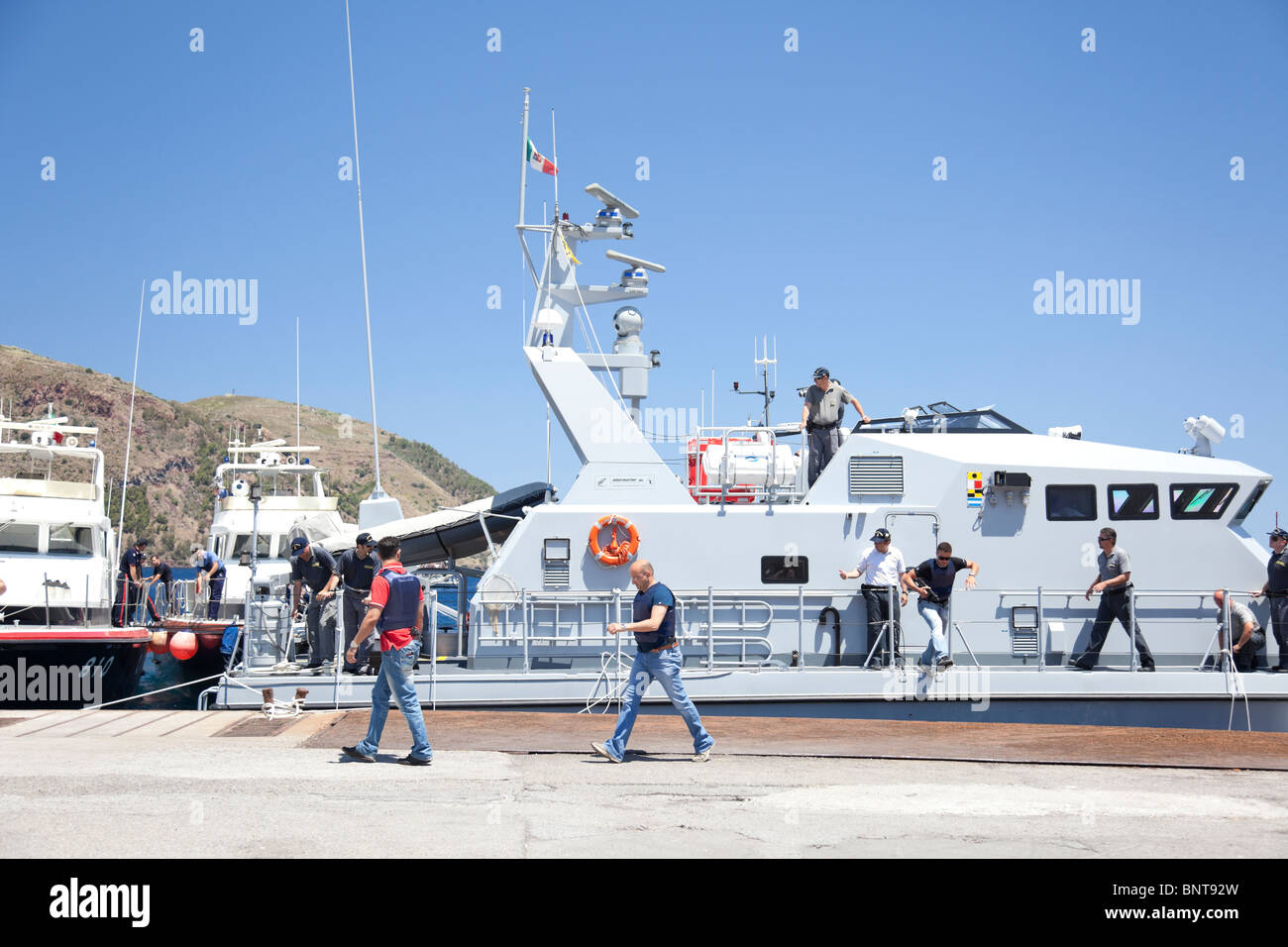 Italian police force Guardia di Finanza having an operation with some vessels and policemen in the port. Stock Photo