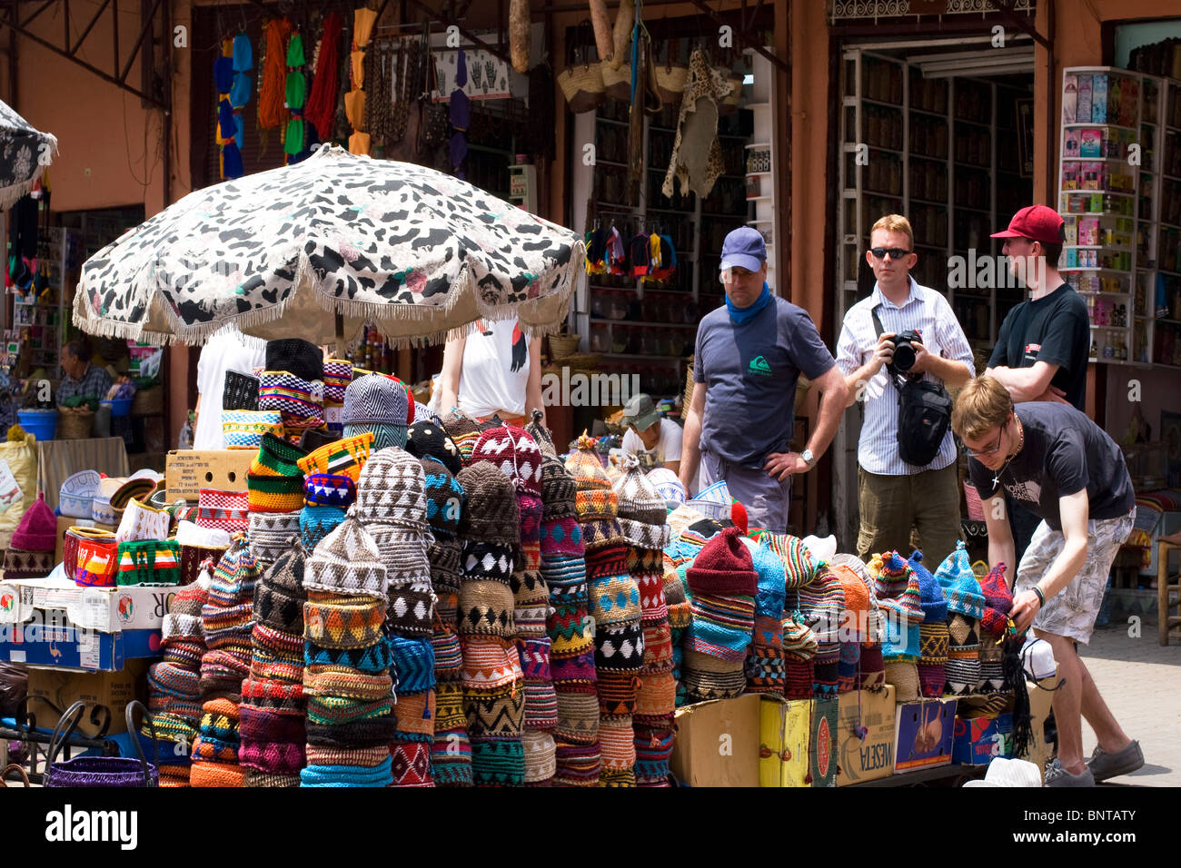Tourists looking at hat stall in Djemaa El Fna Marrakech Morocco Stock Photo
