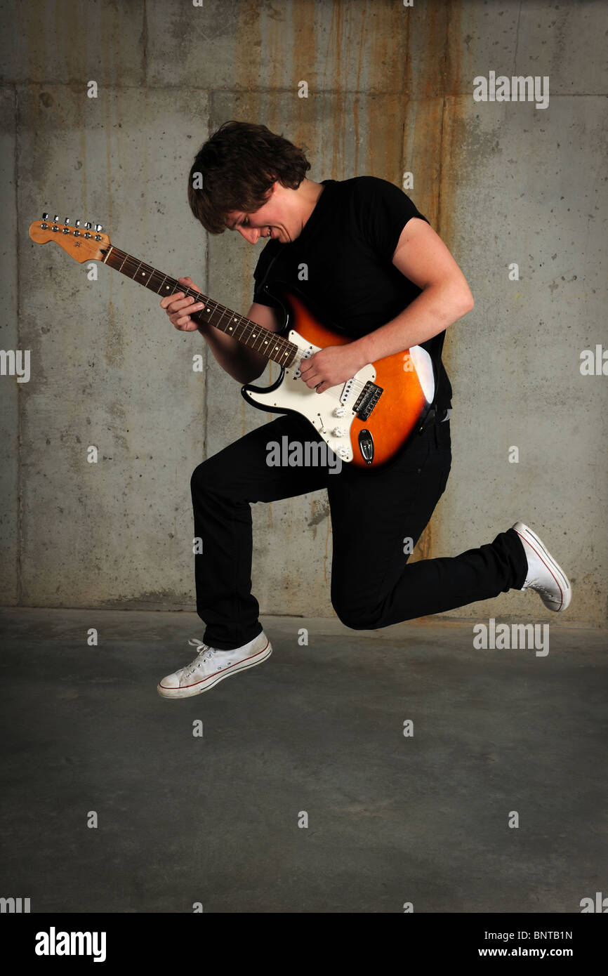 Young guitar player jumping over grunge background Stock Photo Alamy