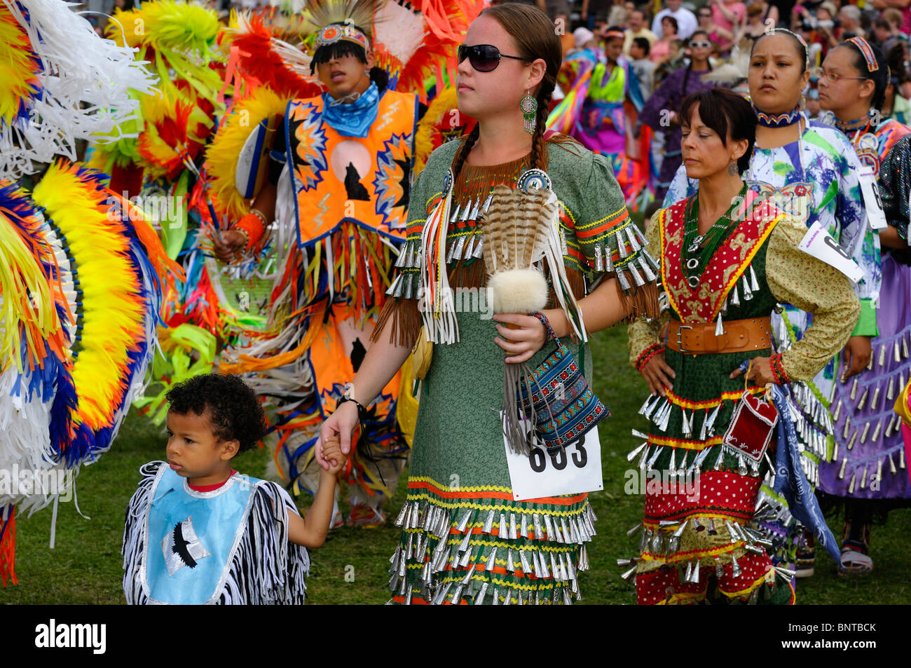 Native Indian male Fancy Dancers and women in jingle dresses at Grand Entry for Six Nations Reserve Pow Wow Grand River Ontario Stock Photo