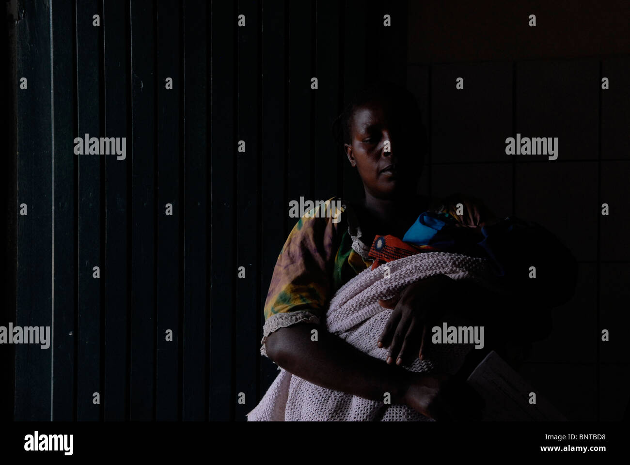 A Congolese woman with her baby waiting for medical assistance in Kiganga medical center. North Kivu province, DR Congo Africa Stock Photo