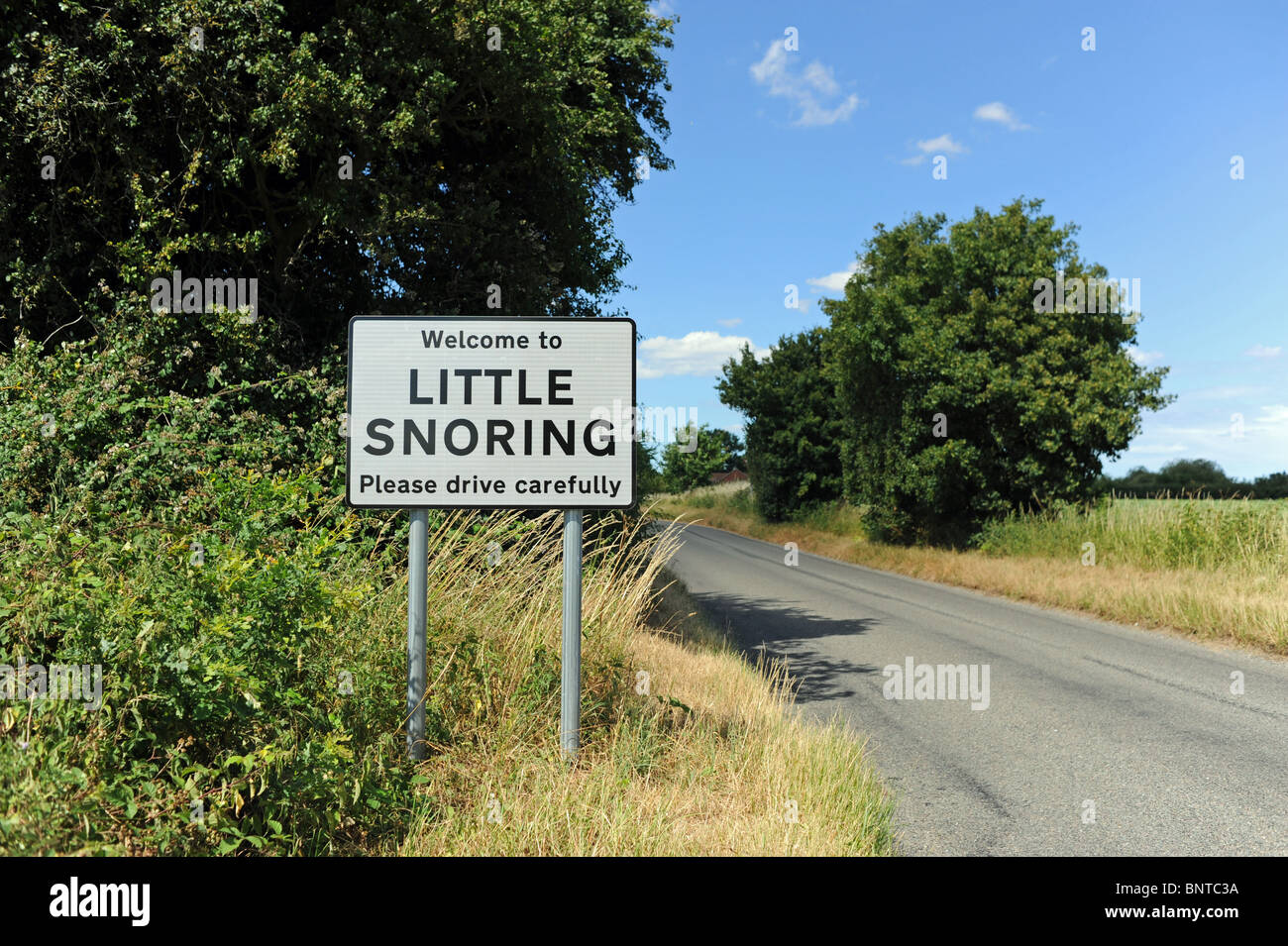 Welcome to Little Snoring Please Drive Carefully village sign in North Norfolk UK Stock Photo