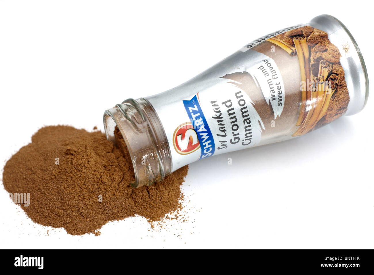 Pile of Cinnamon spilliing from a small glass container Stock Photo