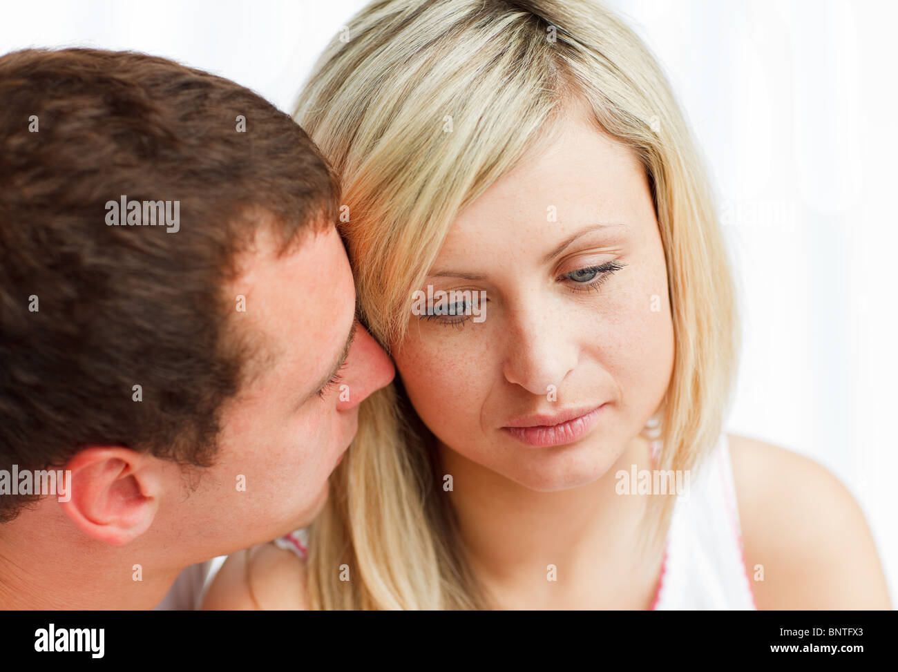 Man kissing a sad woman Stock Photo - Alamy