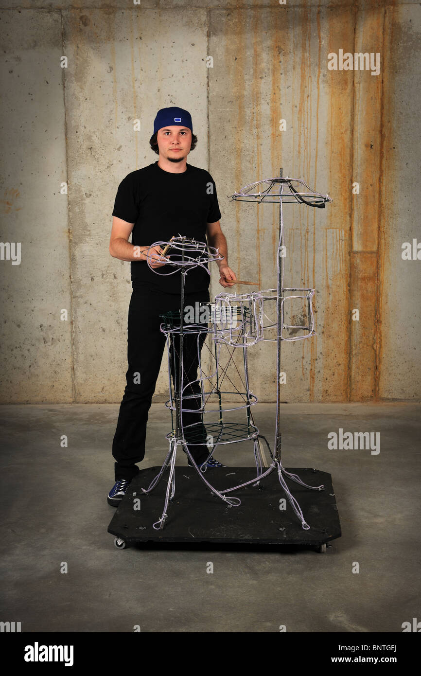 Young drummer playing on make-believe drummer set made of wires over grunge background Stock Photo