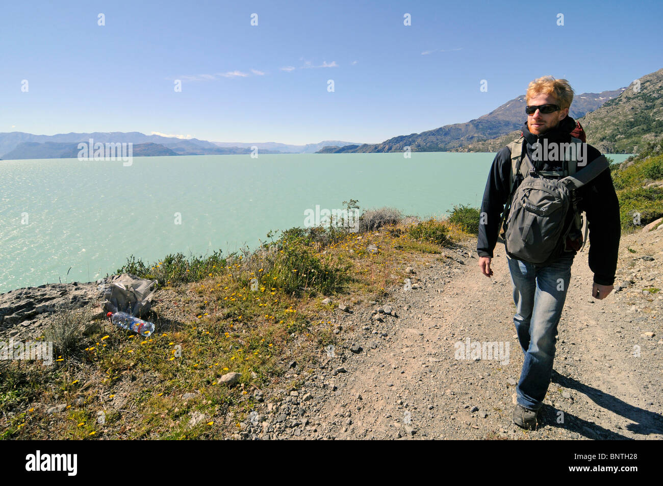 Hiker on a trail alongside the lake o'higgins in Patagonia, Chile. Stock Photo