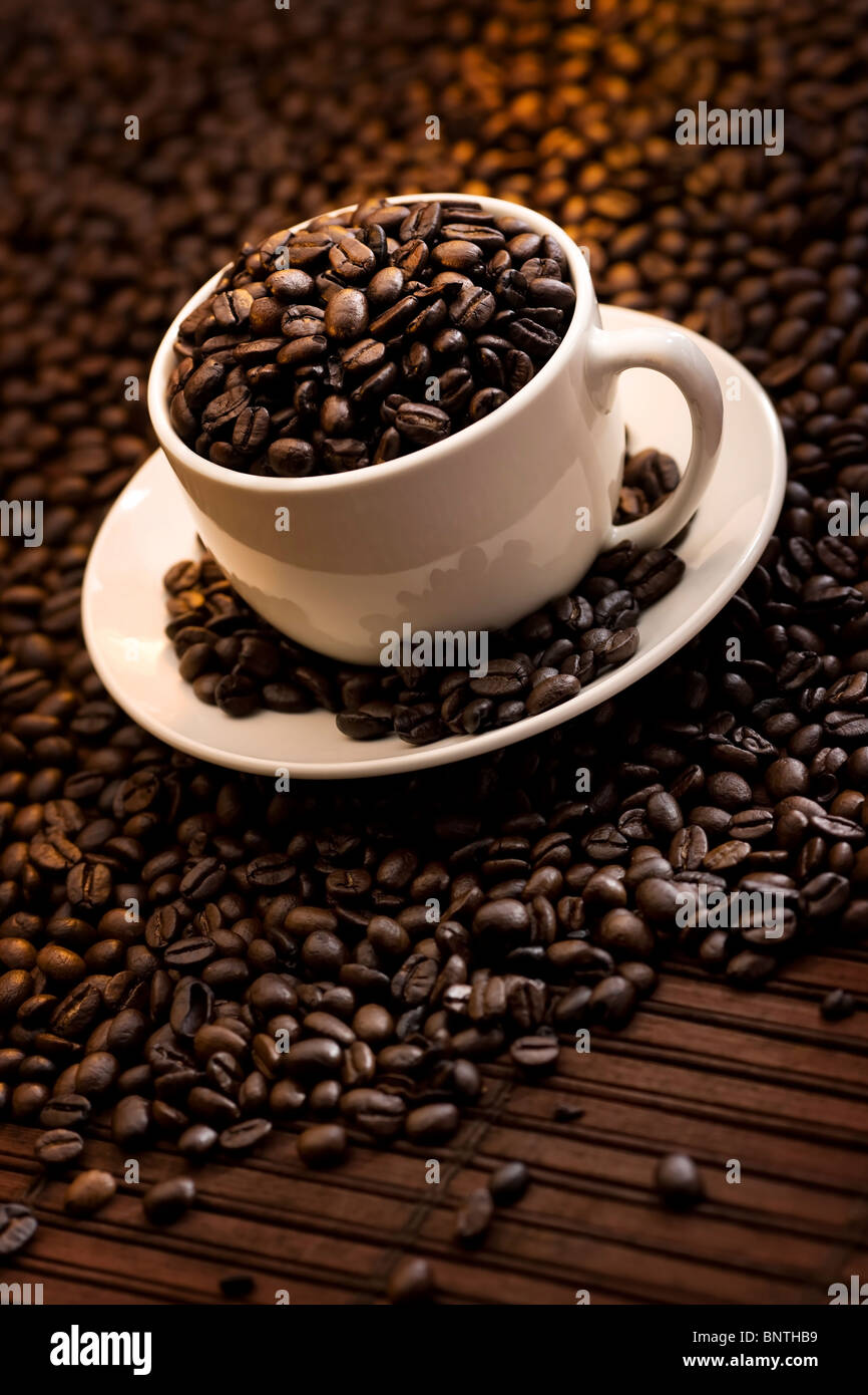 Cup filled with delicious roasted coffee beans Stock Photo