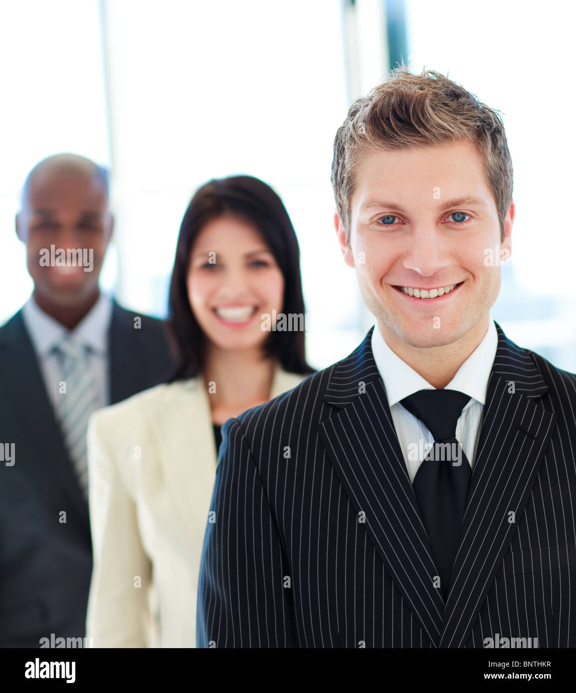 Smiling businessman in front of his team Stock Photo - Alamy