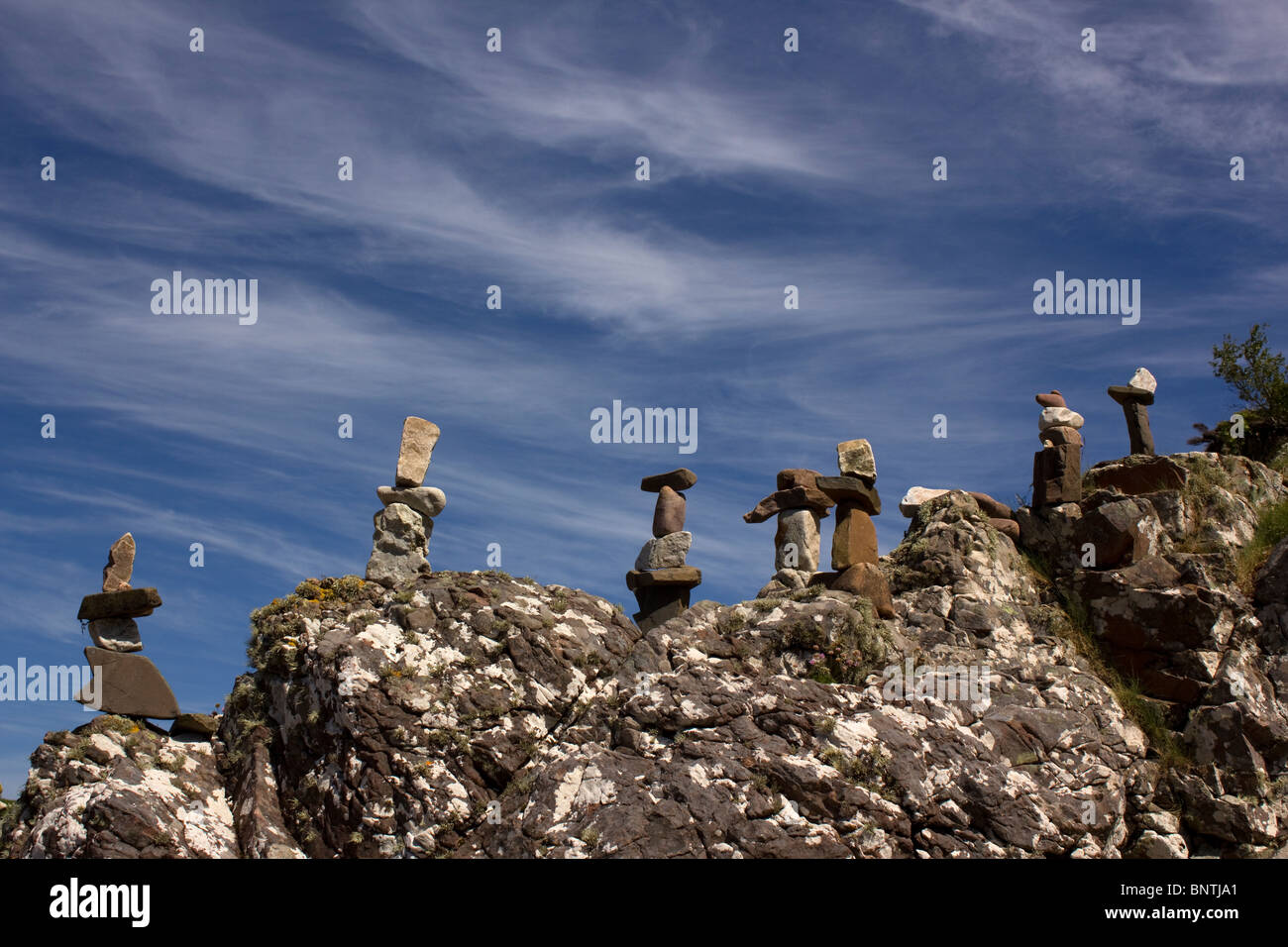 A row of rock sculptures made from balanced rocks and stones against a blue sky at Ord Bay on the Isle of Skye Stock Photo