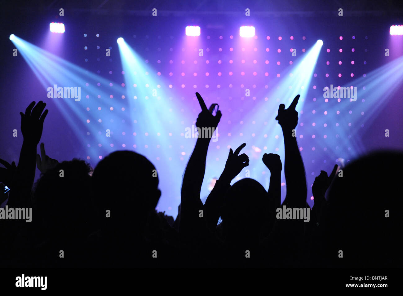 People at a concert silhouetted by the lights Stock Photo