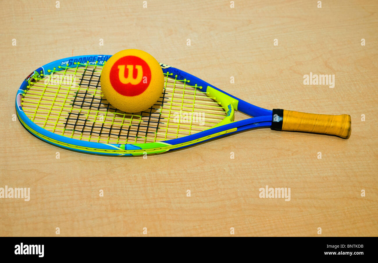 Tennis racket for kids with yellow Wilson ball on the table Stock Photo