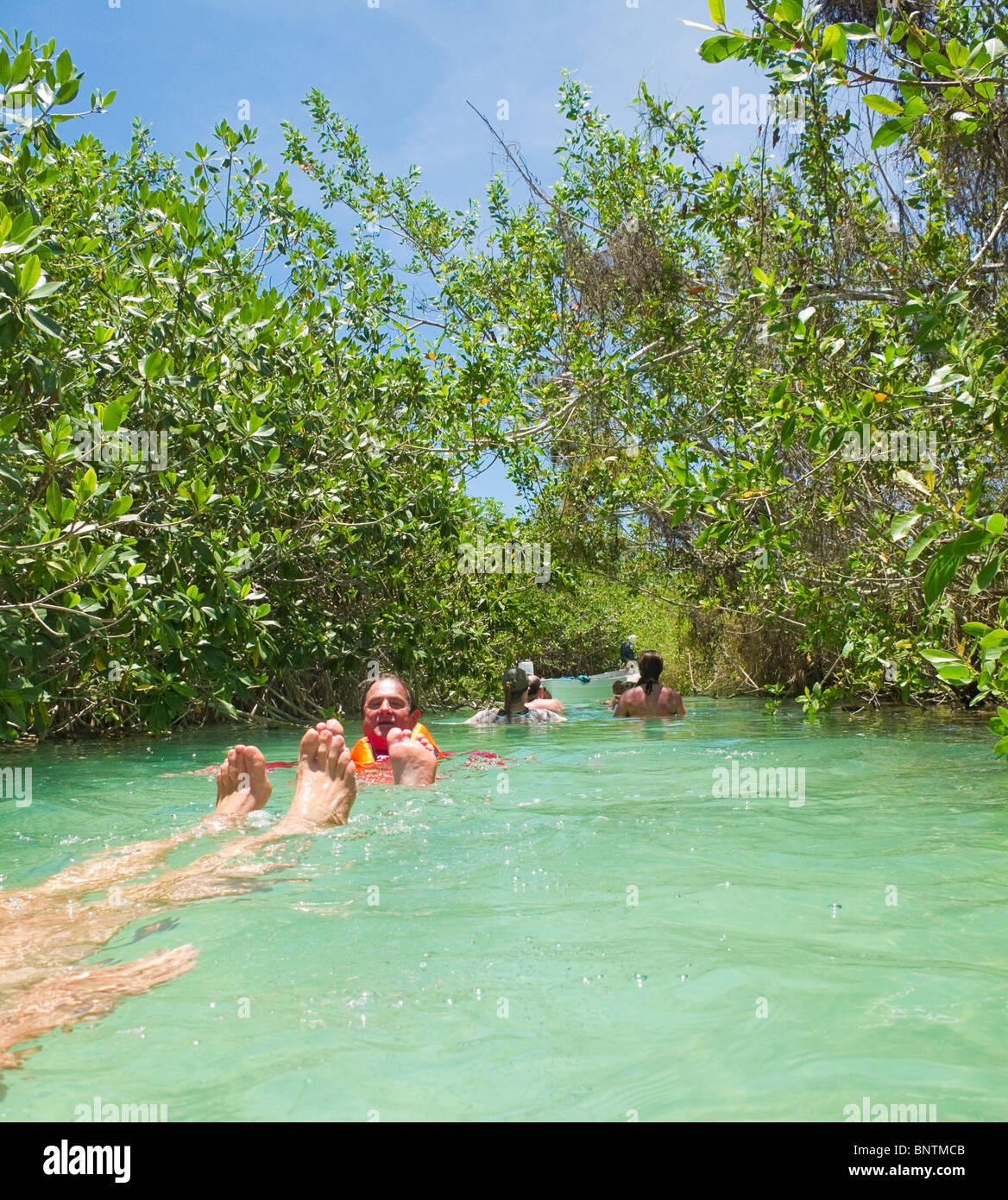 Visitors float down mangrove canal of Sian Ka'an Biosphere Reserve in Riviera Maya. Stock Photo