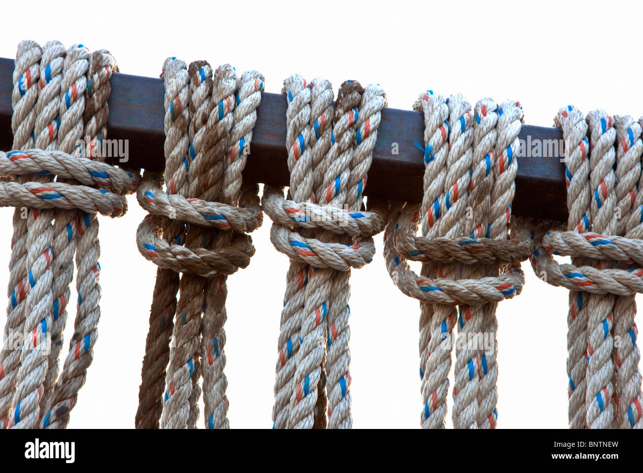 Reverse Lark's Head knots suspended from metal bar Stock Photo