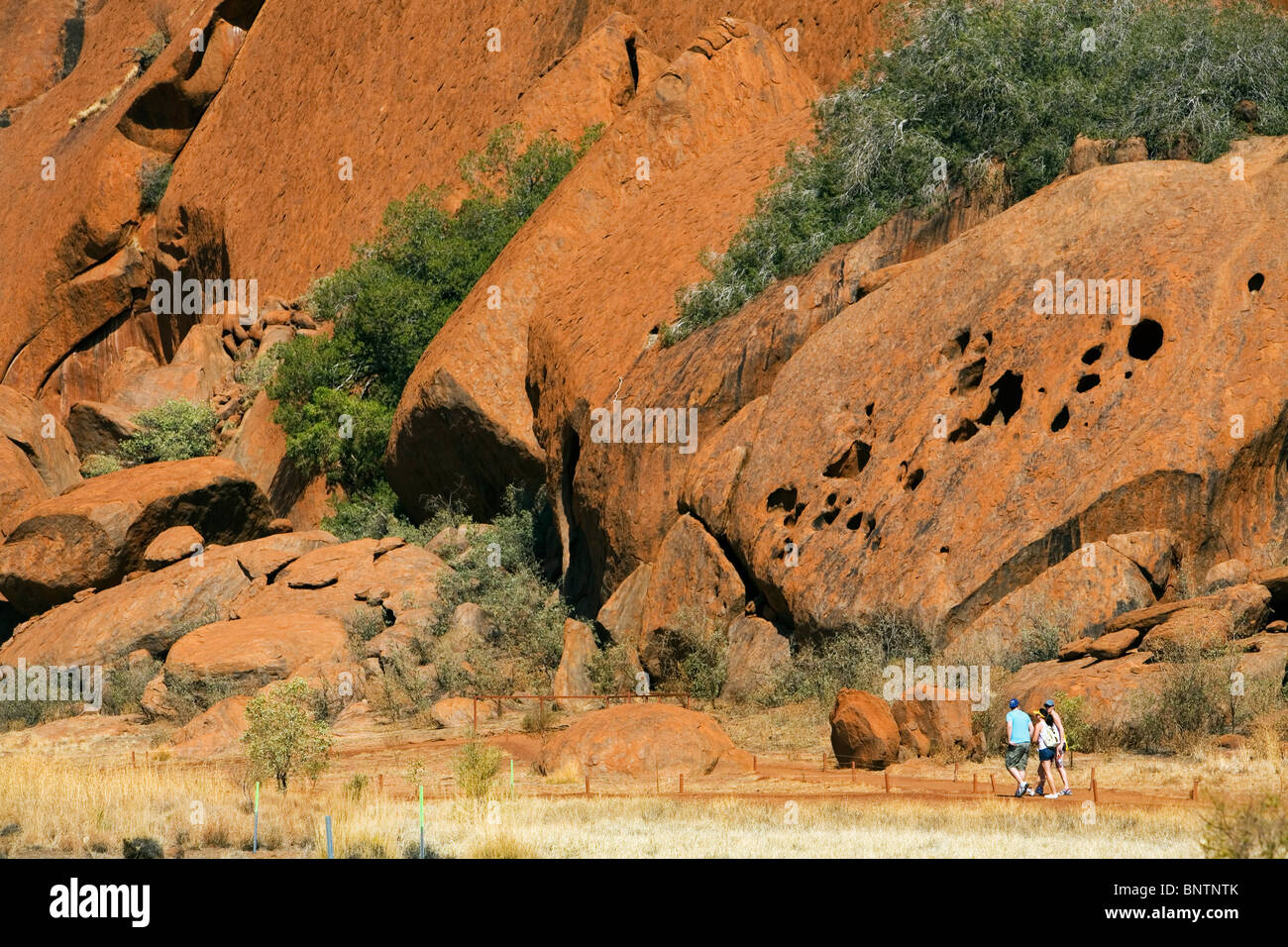 Tourists on the Base Walk at Uluru (Ayers Rock). Uluru-Kata Tjuta National Park, Northern Territory, AUSTRALIA. Stock Photo