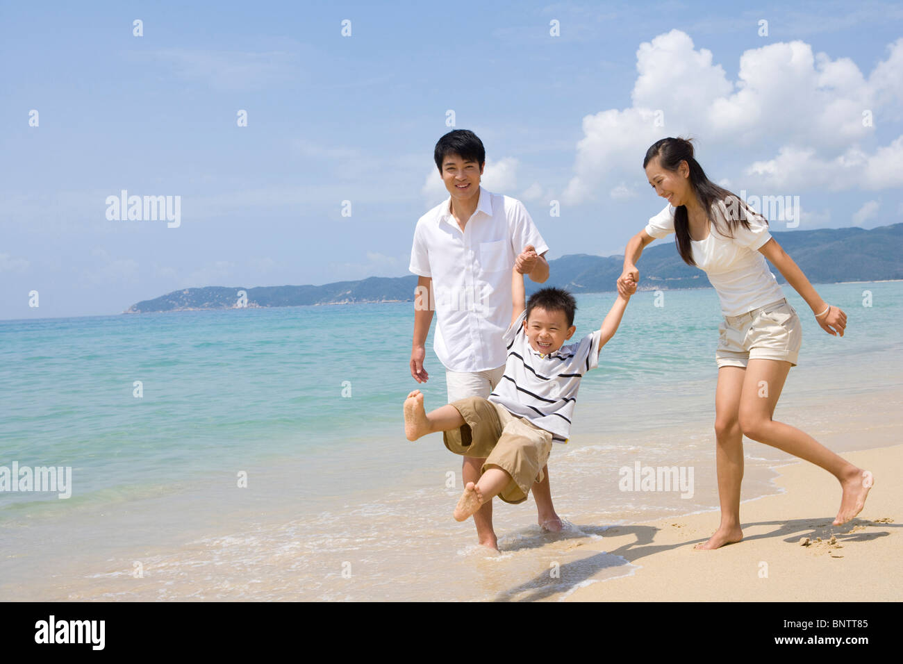 Young family playing on the beach Stock Photo - Alamy