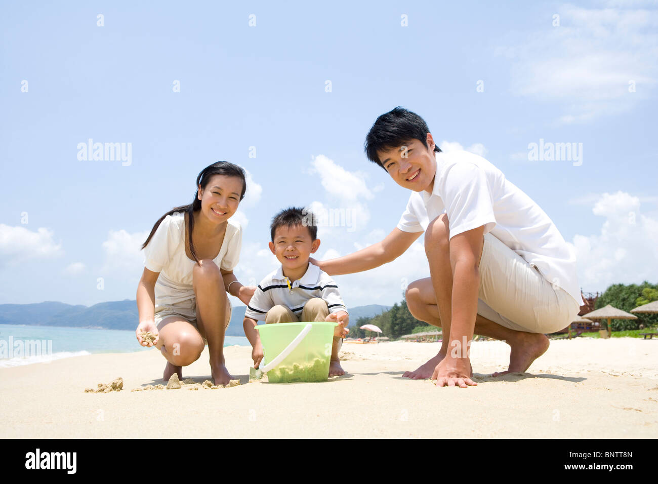 Young family playing on the beach Stock Photo - Alamy