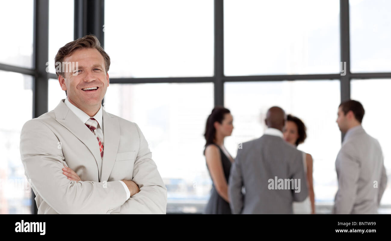 Portrait of a smiling businessman with his team Stock Photo - Alamy
