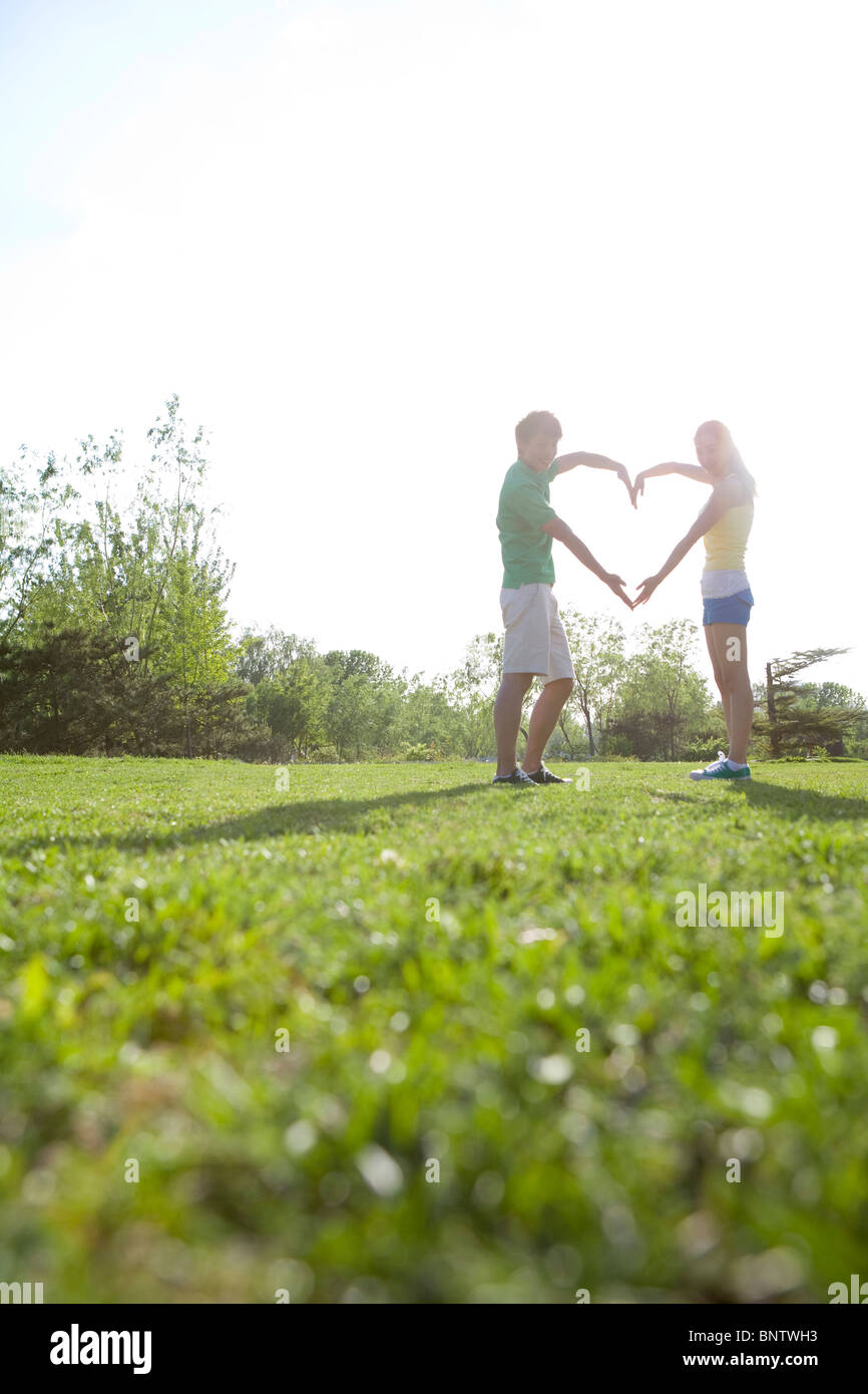 A young couple making a heart shape with their arms Stock Photo - Alamy