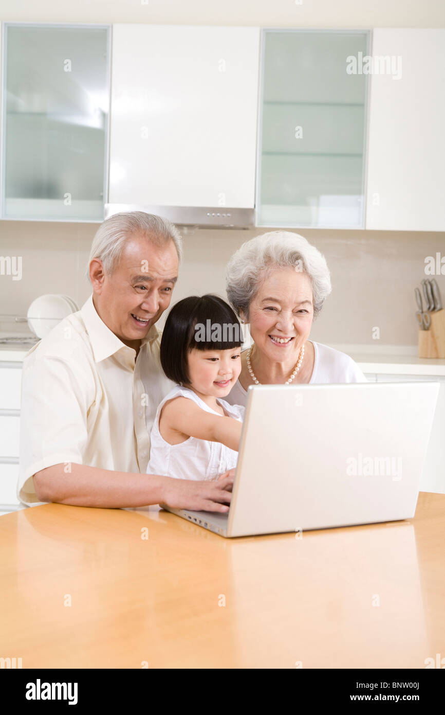 Little girl using a laptop with her grandparents Stock Photo - Alamy