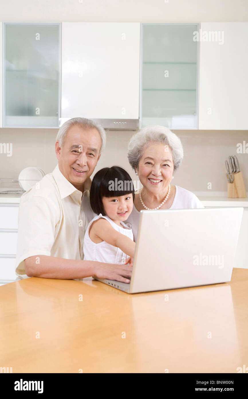 Little girl using a laptop with her grandparents Stock Photo - Alamy
