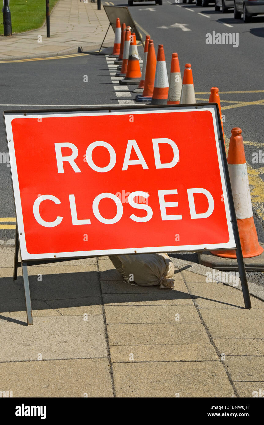 Close up of road closed sign and line of traffic cones Harrogate North Yorkshire England UK United Kingdom GB Great Britain Stock Photo