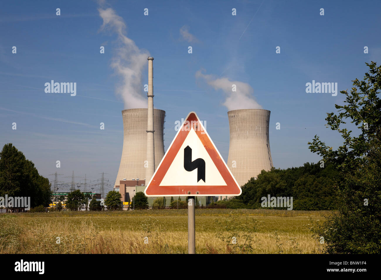 Atomic power plant in Grafenrheinfeld, Germany. In the front a road sign warning of curves. Stock Photo