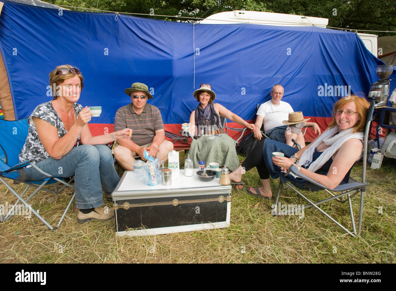 Group of people taking afternoon tea at the Glastonbury Festival, Pilton, Somerset, England, UK. Stock Photo