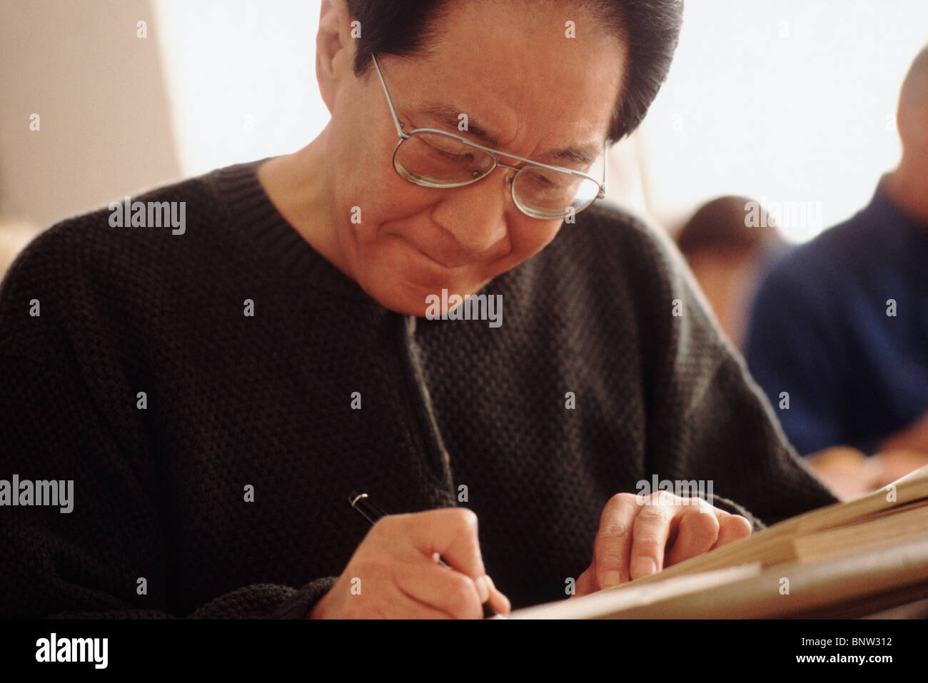 Senior student writing in notebook Stock Photo