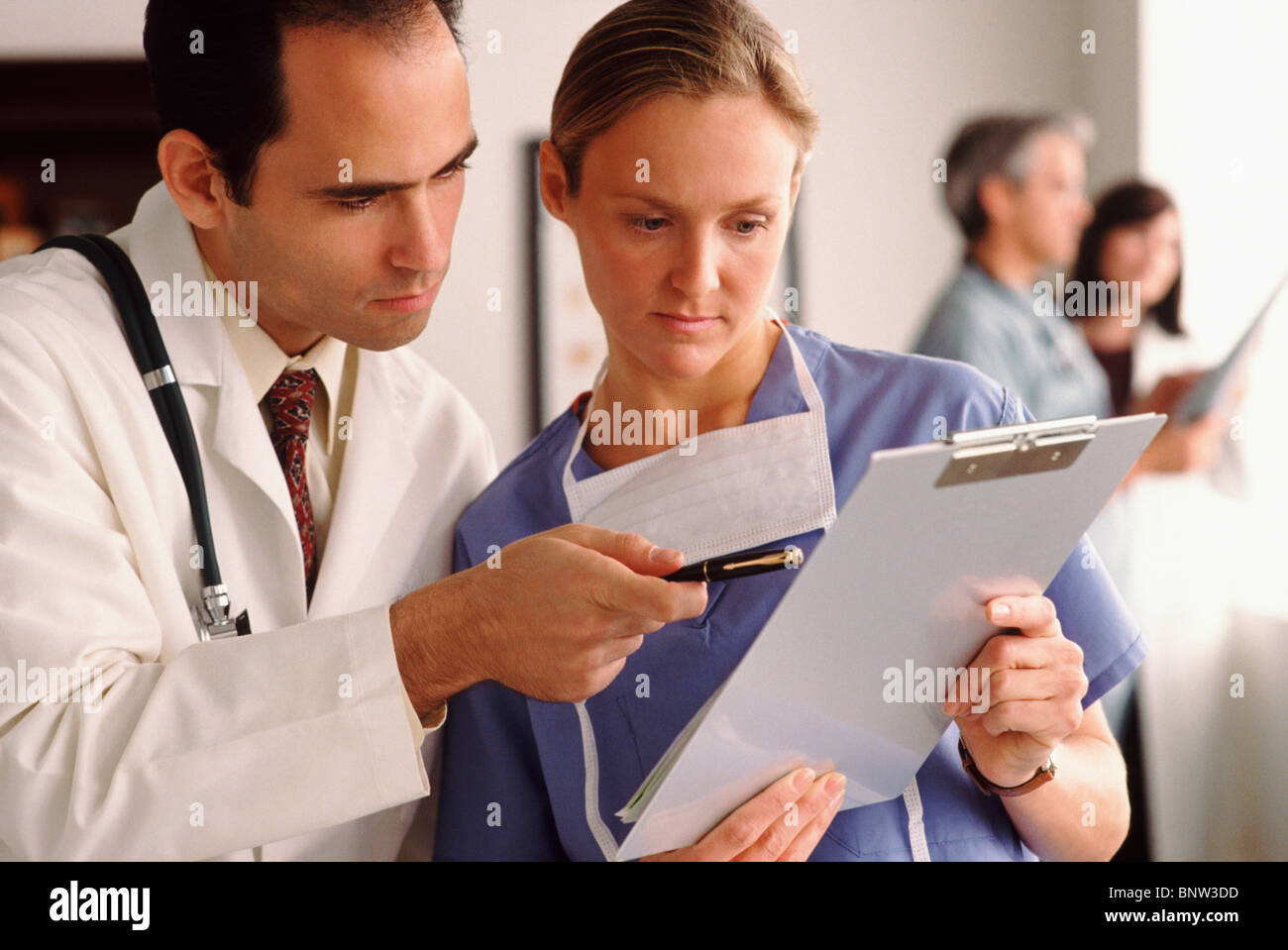 Doctor and nurse looking at chart Stock Photo
